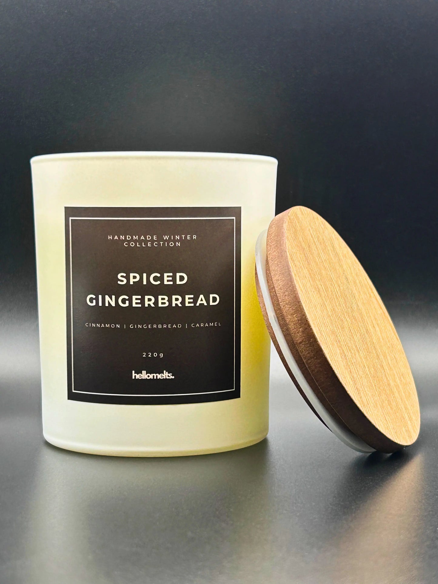 Spiced Gingerbread 220g candle, with lid beside jar, by Hellomelts, rich with scents of cinnamon, gingerbread, and caramel, presented in a white matt jar with wooden lid.