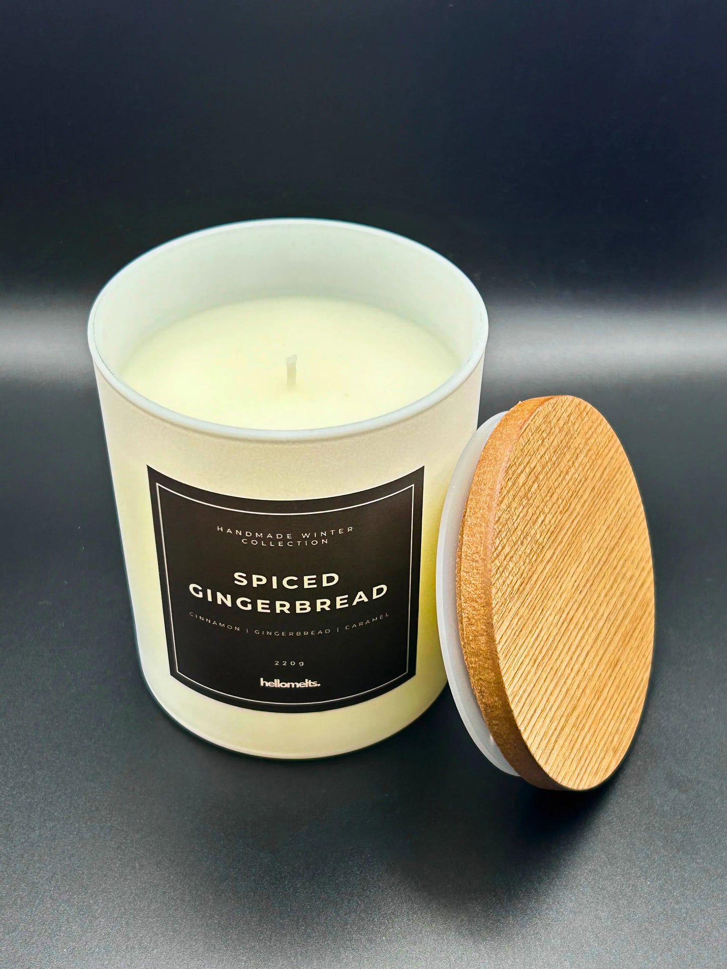 Spiced Gingerbread 220g candle, by Hellomelts, showing a top view with lid beside jar, rich with scents of cinnamon, gingerbread, and caramel, presented in a white matt jar with wooden lid.