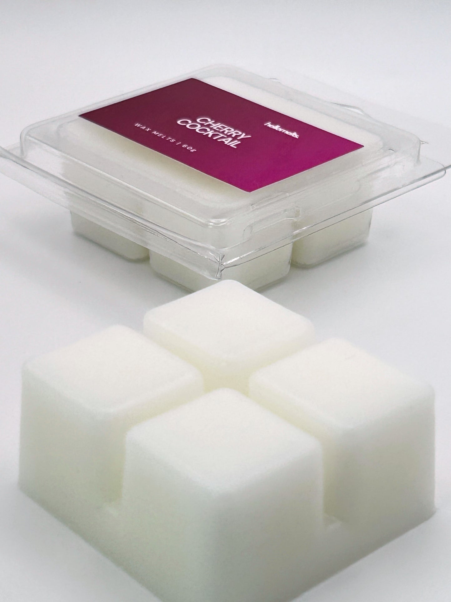 Angled shot of Cherry Cocktail 60g wax melt bar in front of its packaging, part of the Hellomelts Summer Collection