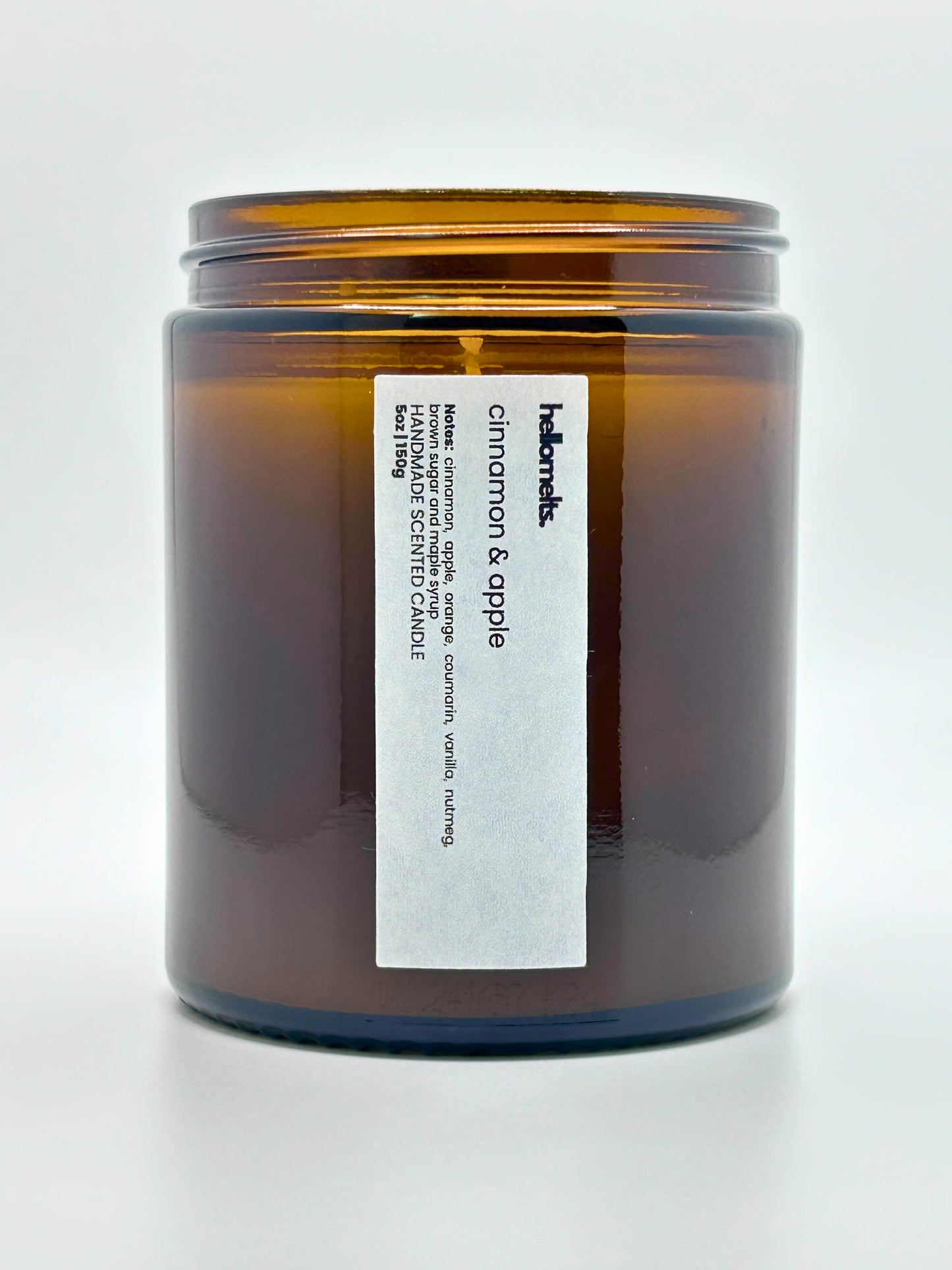 Close-up front view of Cinnamon & Apple autumn scented candle by Hellomelts with the lid off, part of the Autumn Collection