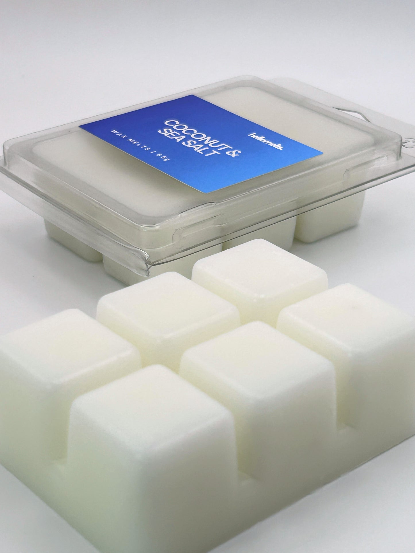 Angled shot of Coconut & Sea Salt 85g wax melt bar in front of its packaging, part of the Summer Collection by Hellomelts