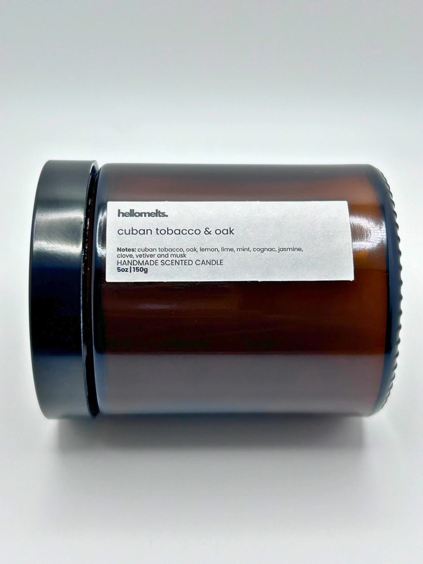Close-up of Cuban Tobacco & Oak candle by Hellomelts lying down with the lid on, part of the autumn collection.