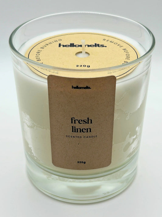 Angled front view of the Fresh Linen candle with the branded cardboard wick cover on, from the Hellomelts Spring Collection.