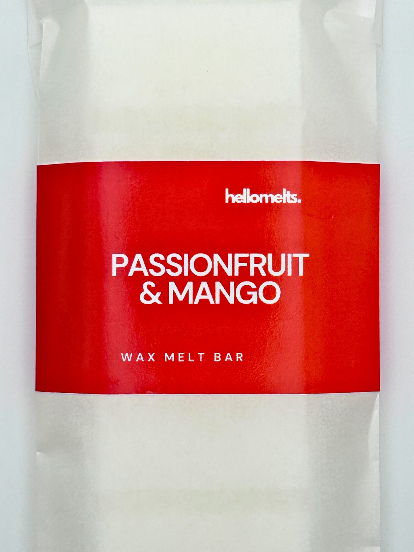 Close-up of the Passionfruit & Mango wax melt bar label in bold red, featuring the Hellomelts branding and product name.