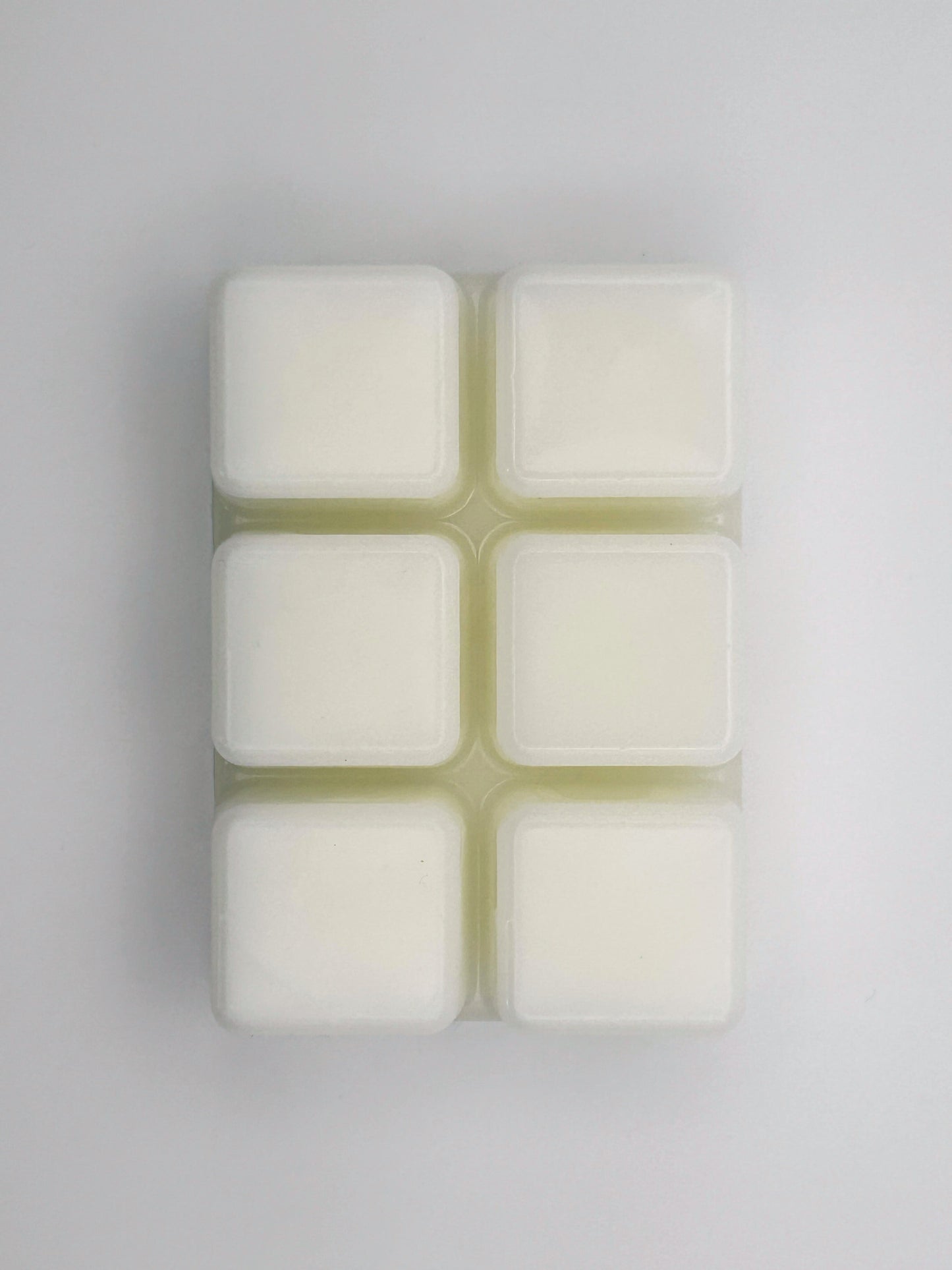 Flatlay of Passionfruit & Mango wax melt bar in 85g size, removed from packaging to show 6 cubed wax melt bar
