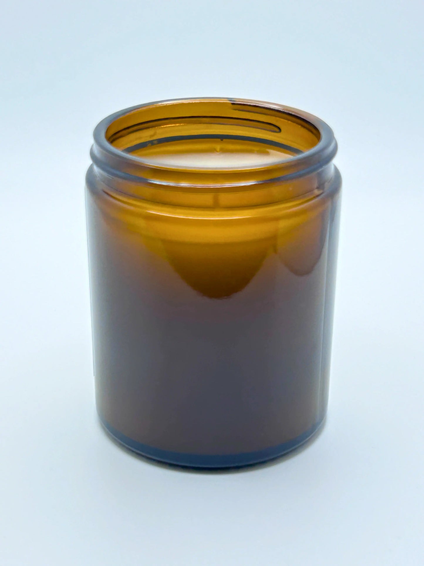 Back view of Sandalwood & Black Pepper candle from Hellomelts, featuring an amber jar from the autumn collection.