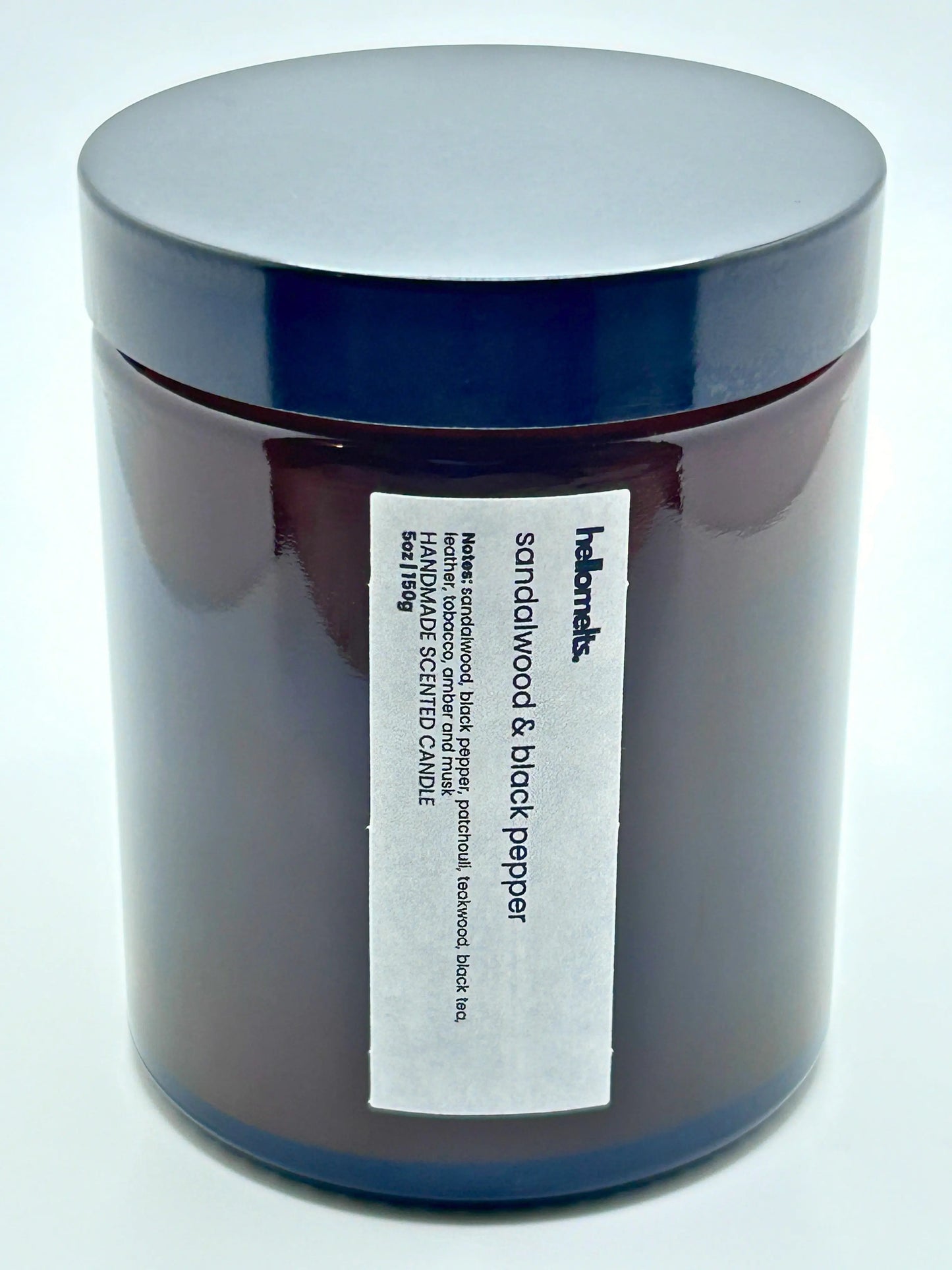 Close-up front view of Sandalwood & Black Pepper candle by Hellomelts with the lid on, part of the autumn collection.