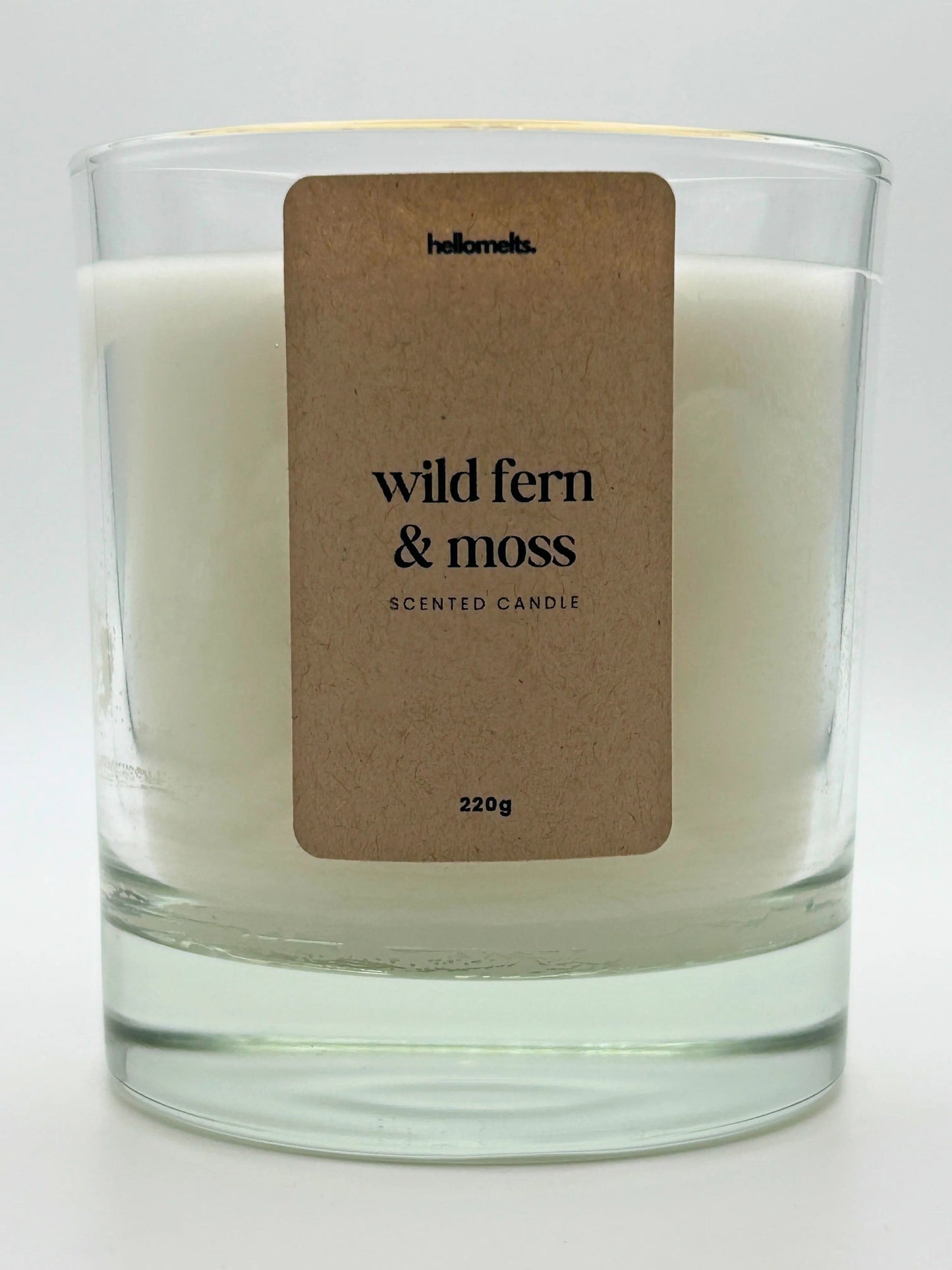 Close-up of the Wild Fern & Moss candle label showing scent name and weight, a handcrafted candle by Hellomelts for the Spring Collection.