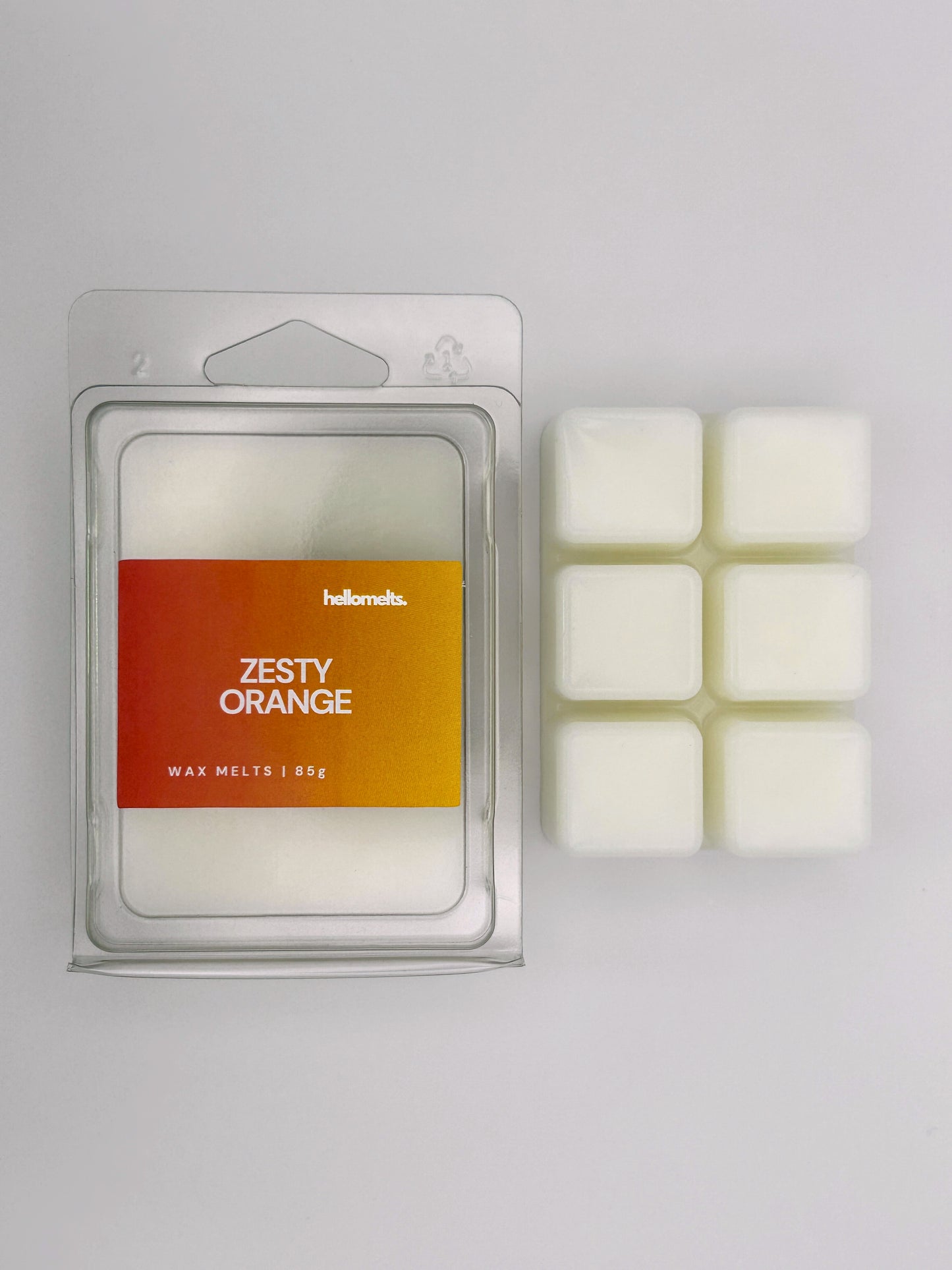Zesty Orange 85g wax melt bar by Hellomelts pictured beside its clamshell packaging, part of the Summer Collection