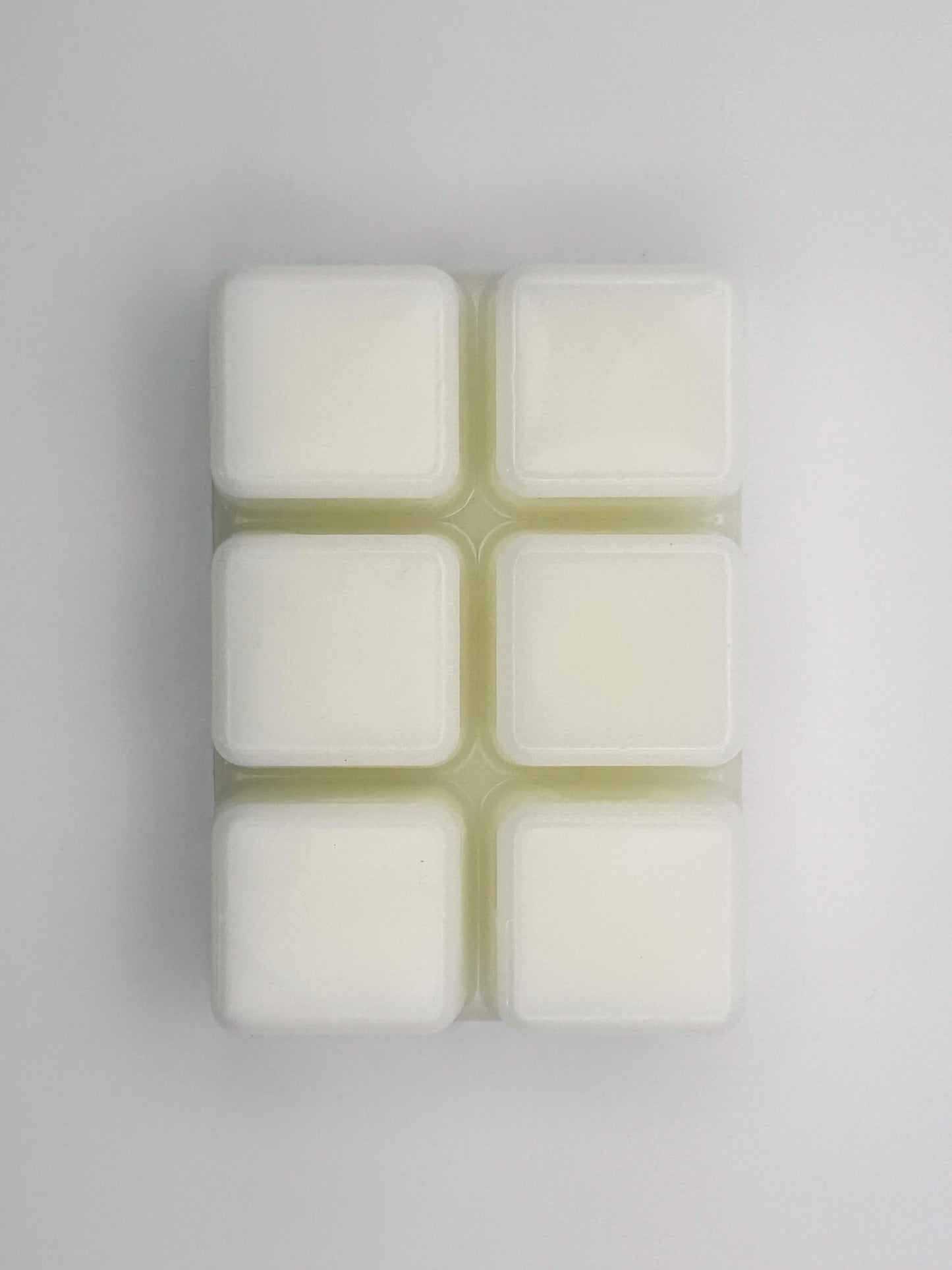 Flatlay of Zesty Orange wax melt bar in 85g size, removed from packaging to show 6 cubed wax melt bar