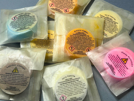 Old Hellomelts wax melt samples packaged in glassine bags showing oil seepage and damaged labels, prior to the new clamshell packaging upgrade to our Summer Collection