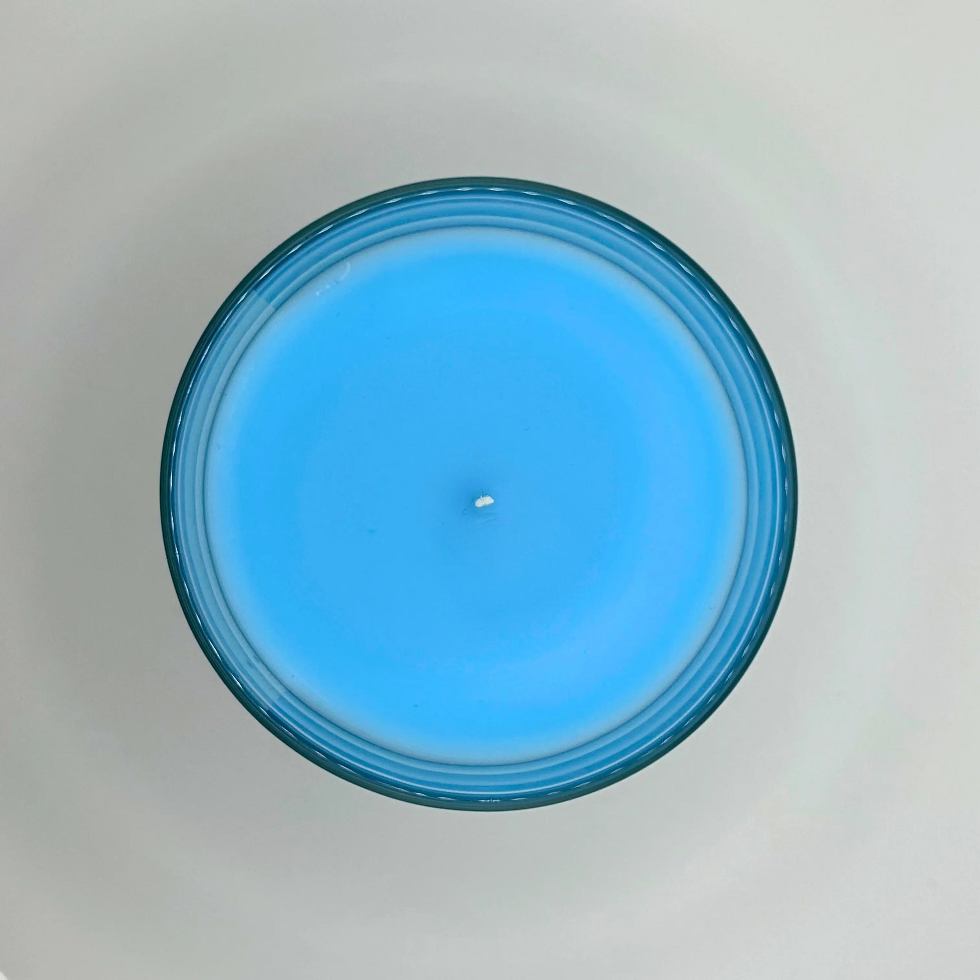 Bergamot Beach 220g candle, showing top view of wax, by Hellomelts, infused with refreshing bergamot, lily and a hint of coconut, in a beach-inspired blue wax.