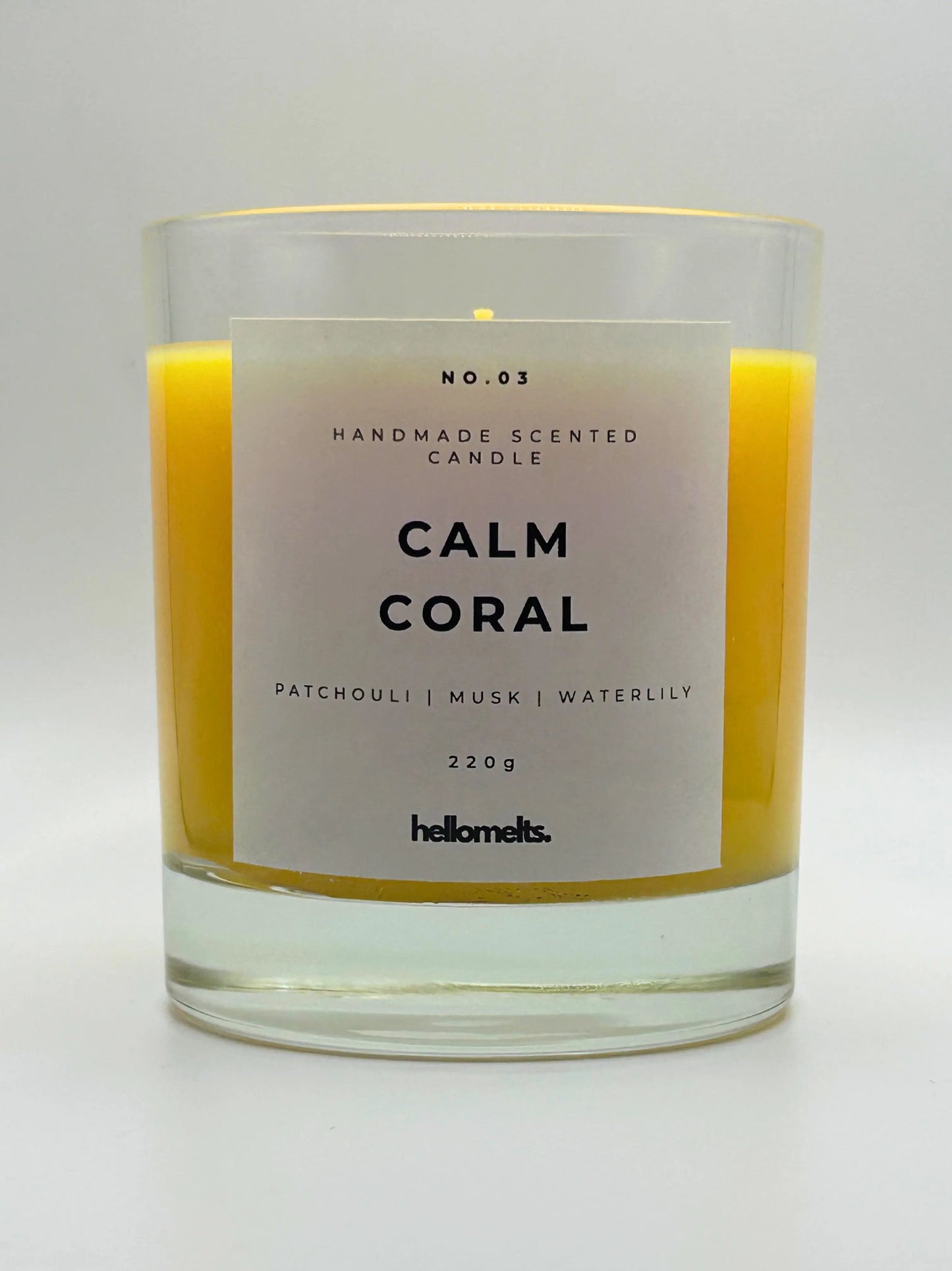 Calm Coral 220g candle, with no lid, by Hellomelts, blending patchouli with soothing scents of musk and a touch of waterlily, in a bright yellow wax.