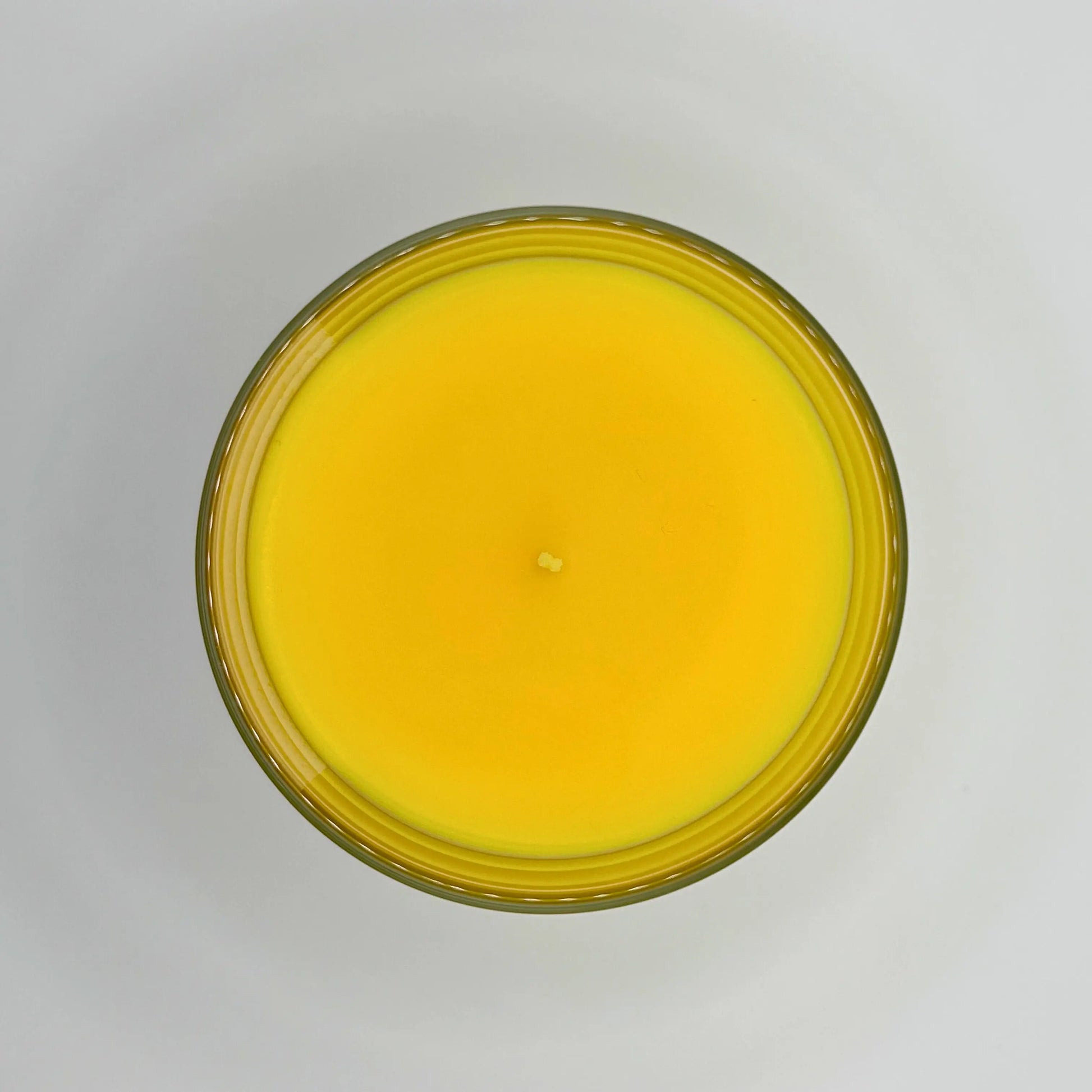 Calm Coral 220g candle, showing top view of wax, by Hellomelts, blending patchouli with soothing scents of musk and a touch of waterlily, in a bright yellow wax.