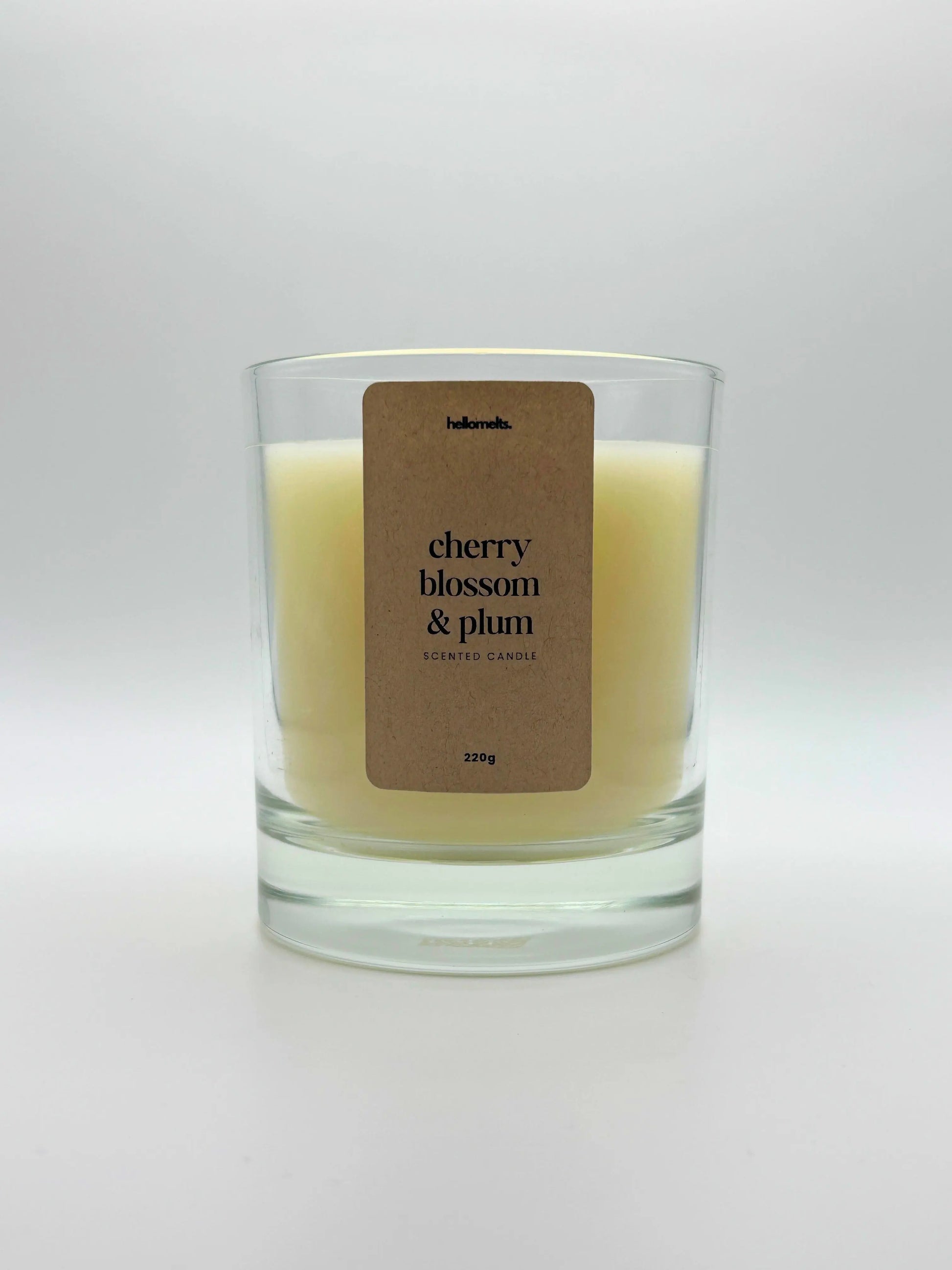 Front view of Cherry Blossom & Plum scented candle by Hellomelts, featuring a soft off-white wax in a clear glass jar, part of the Spring Collection.