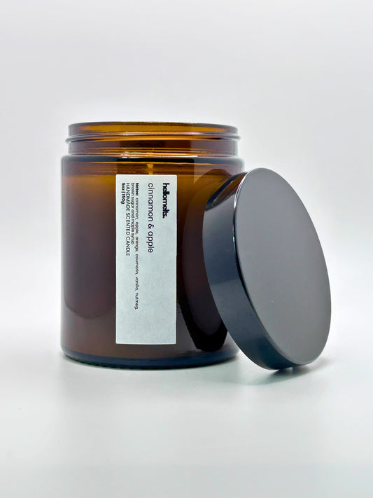 Front view of Cinnamon & Apple autumn scented candle by Hellomelts with the lid placed beside it, part of the Autumn Collection