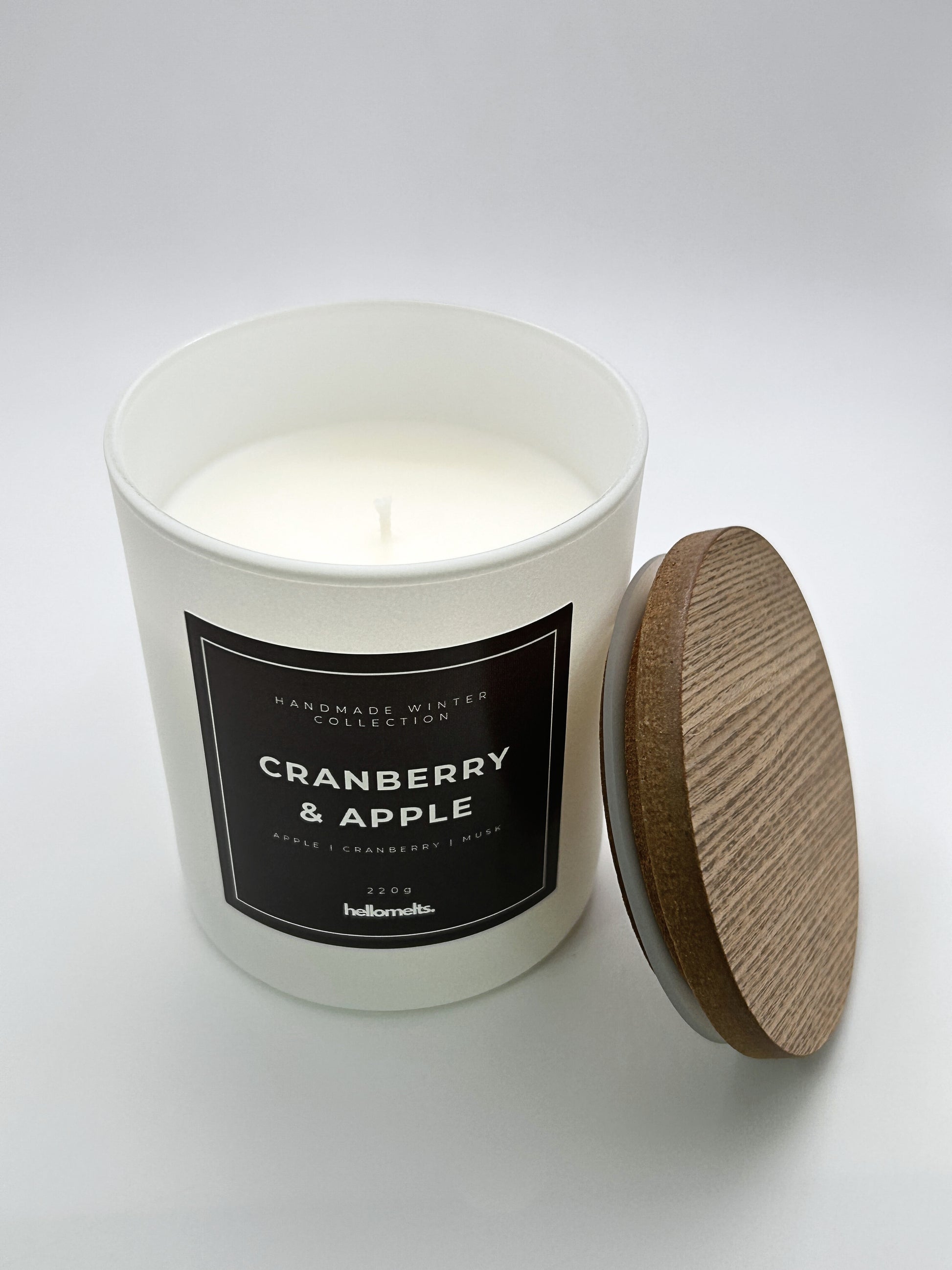Cranberry & Apple 220g candle top-down view with the wooden lid placed beside the jar, part of the Hellomelts Winter Collection