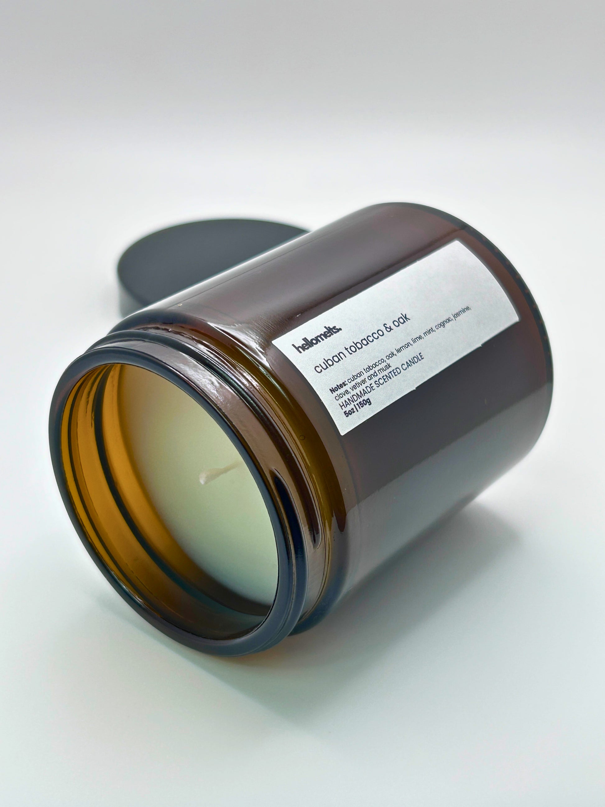 Cuban Tobacco & Oak autumn scented candle by Hellomelts lying on its side with the wick facing forward, part of the Autumn Collection