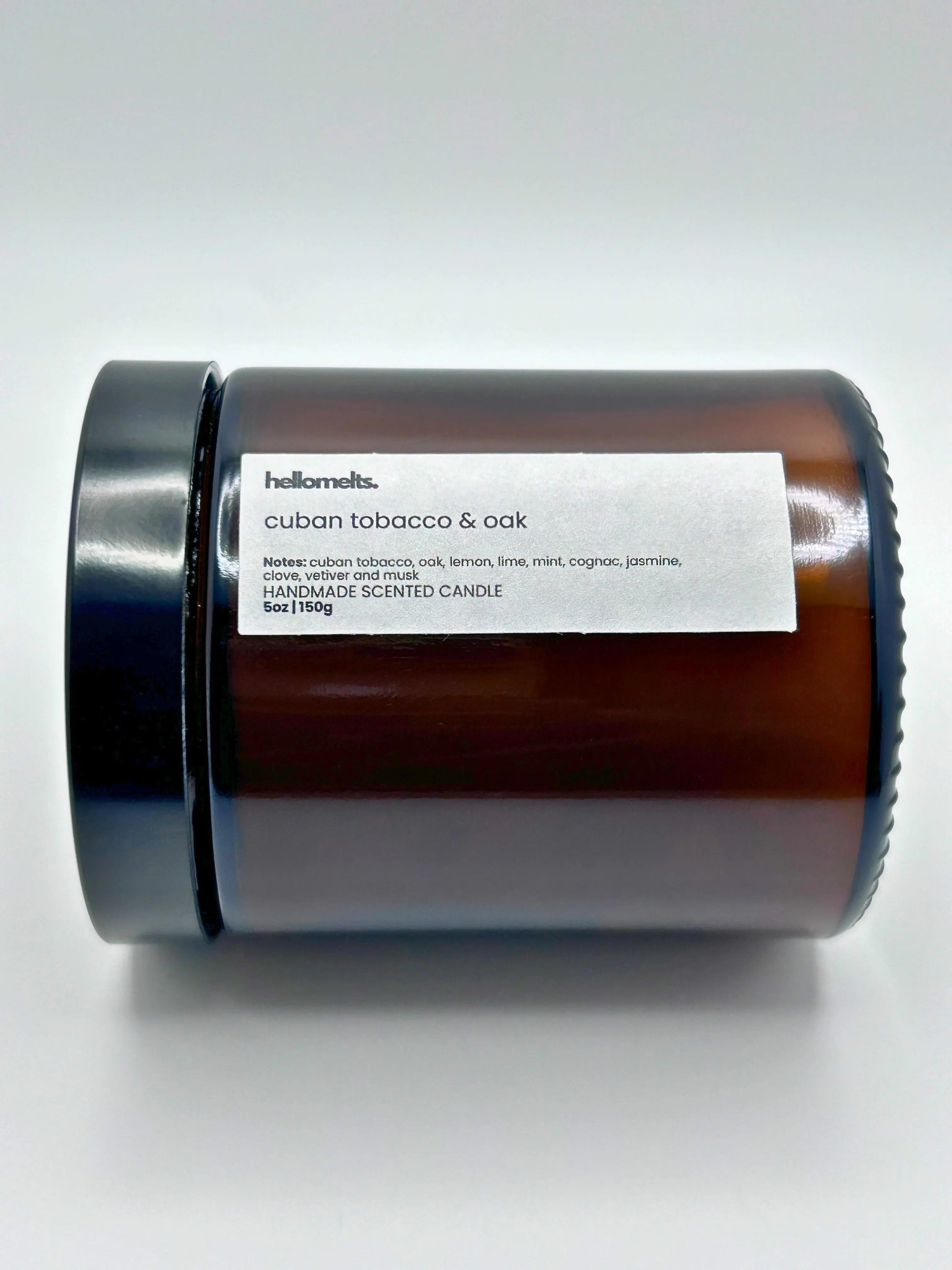 Close-up of Cuban Tobacco & Oak candle by Hellomelts lying down with the lid on, part of the autumn collection.
