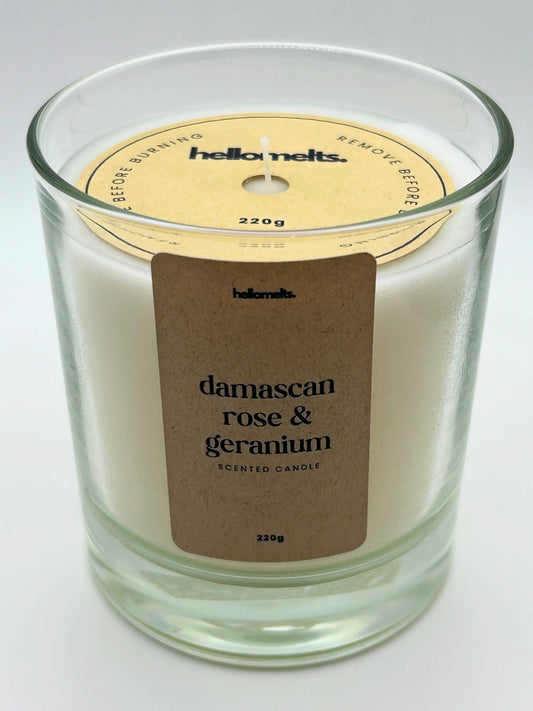 Angled front view of the Damascan Rose & Geranium candle with the branded cardboard wick cover on, from the Hellomelts Spring Collection.