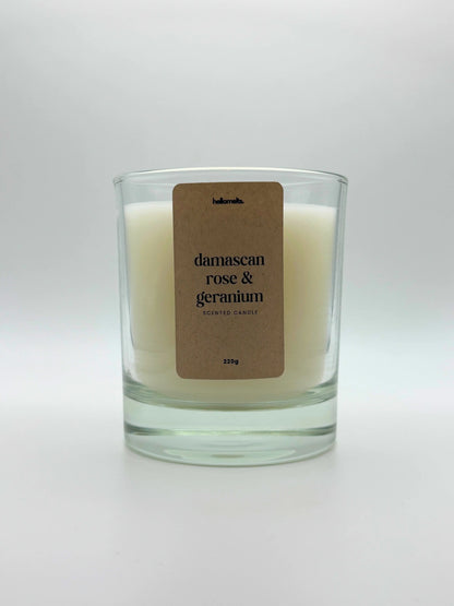 Front view of Damascan Rose & Geranium scented candle by Hellomelts, featuring a clean white wax in a clear glass jar, part of the Spring Collection.