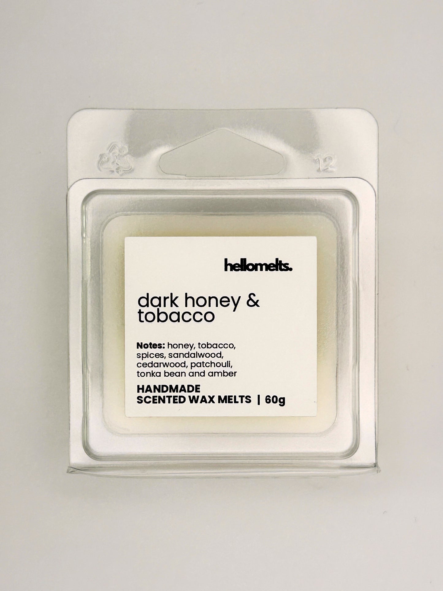 Close up of Dark Honey & Tobacco 60g wax melt label on clear clamshell packaging from the Hellomelts Autumn Collection