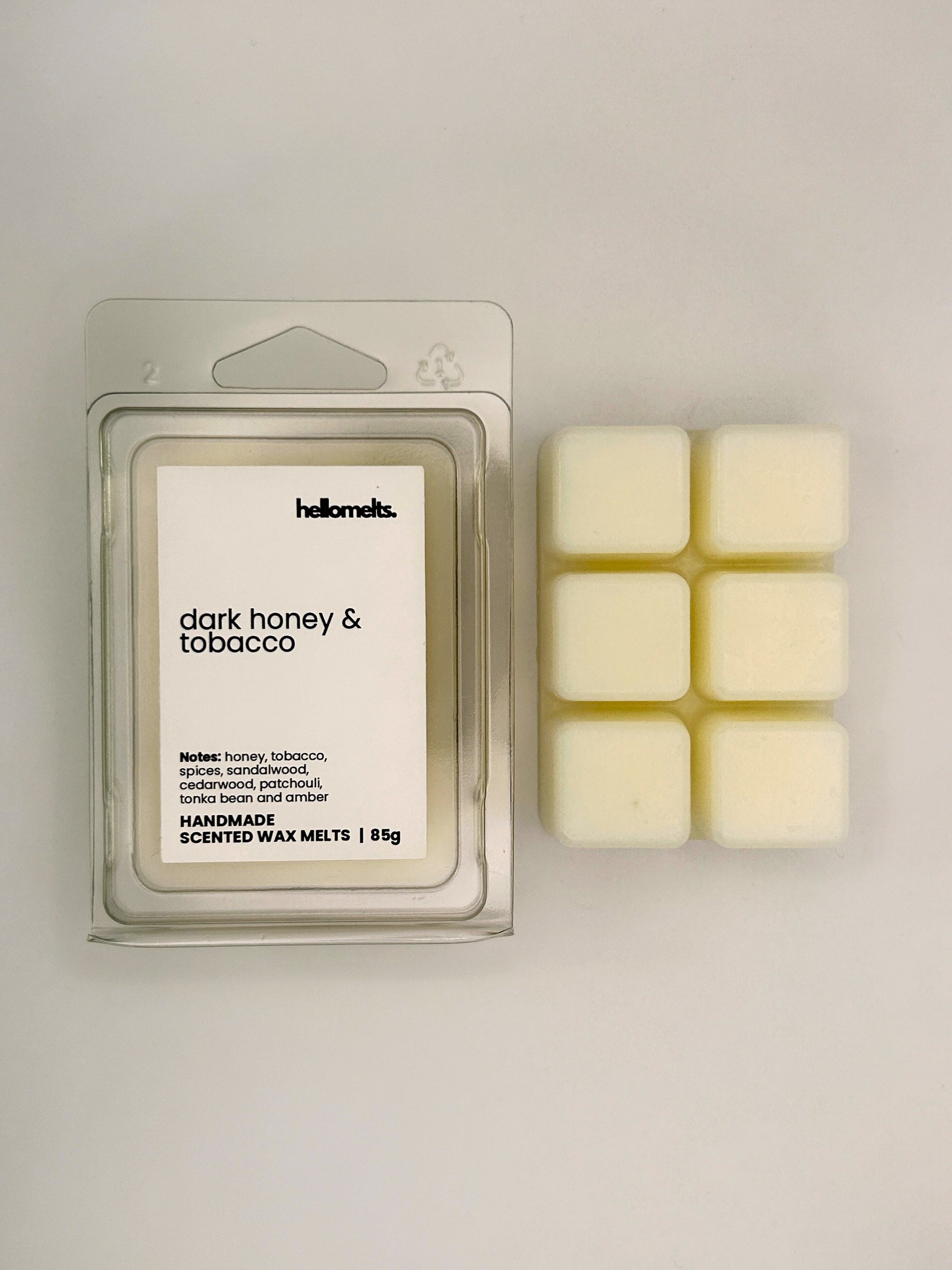 Dark Honey & Tobacco 85g wax melt bar displayed beside its clear clamshell packaging from the Hellomelts Autumn Collection