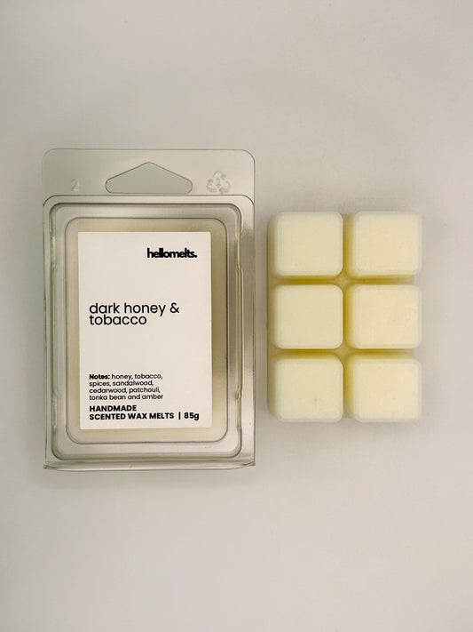 Dark Honey & Tobacco 85g wax melt bar displayed beside its clear clamshell packaging from the Hellomelts Autumn Collection