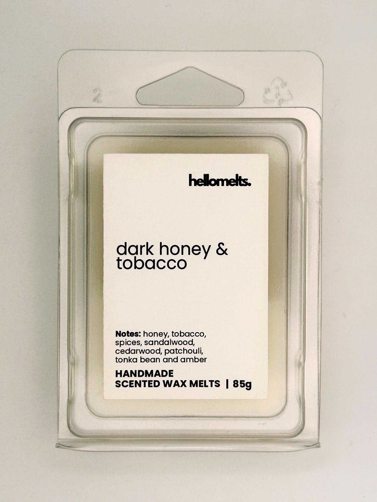 Close up of Dark Honey & Tobacco 85g wax melt label on clear clamshell packaging from the Hellomelts Autumn Collection