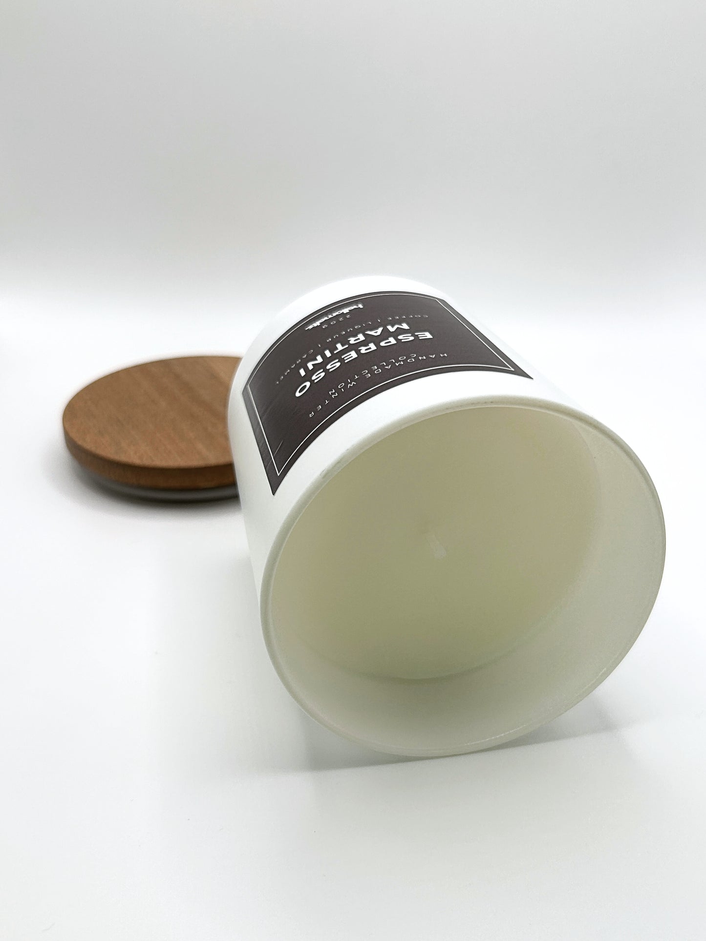 Espresso Martini 220g candle laid on its side with the lid in the background, showing the matte white jar from the Hellomelts Winter Collection