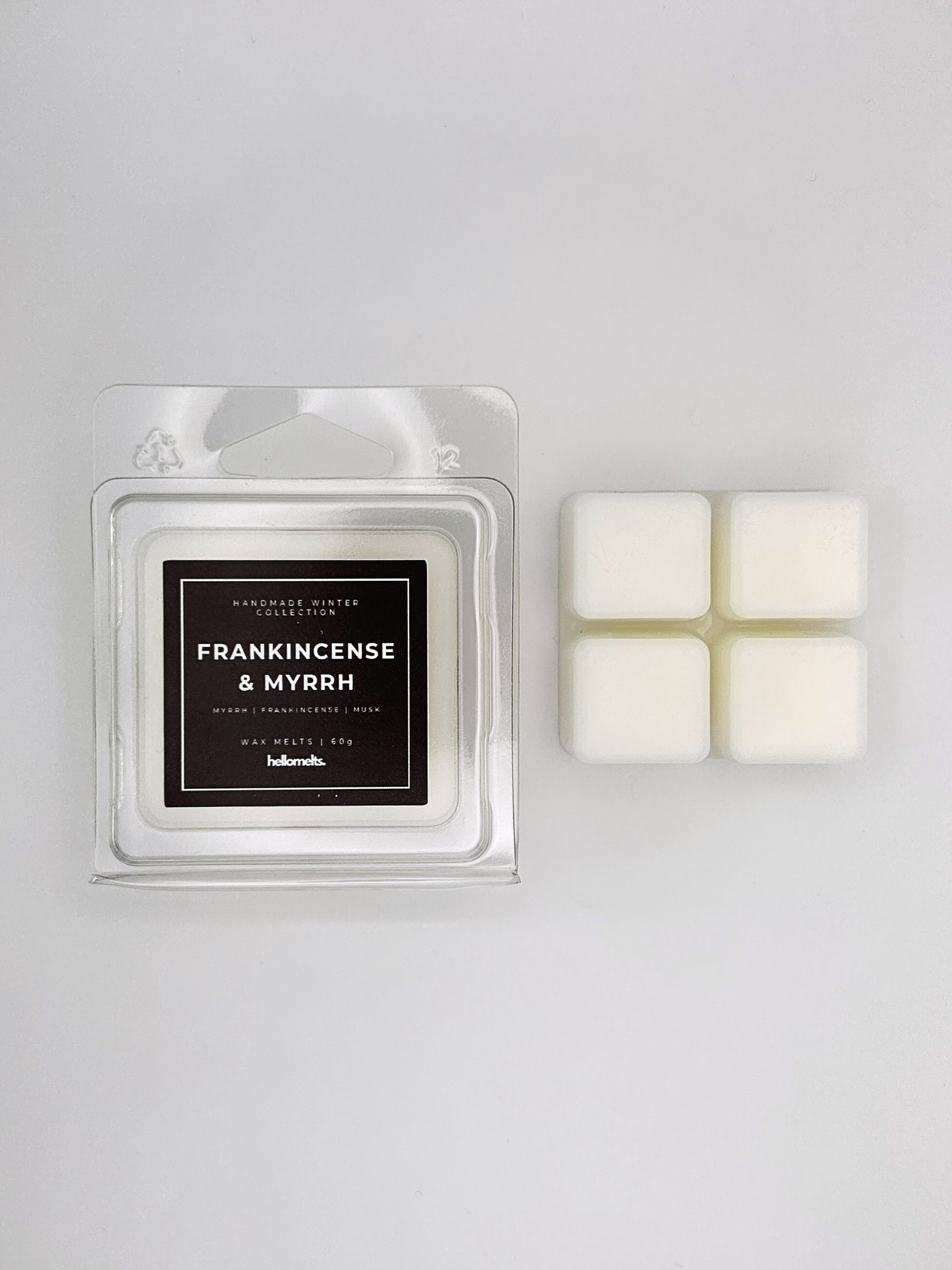 Frankincense & Myrrh 60g wax melt clamshell placed beside four wax cubes from the Hellomelts Winter Collection