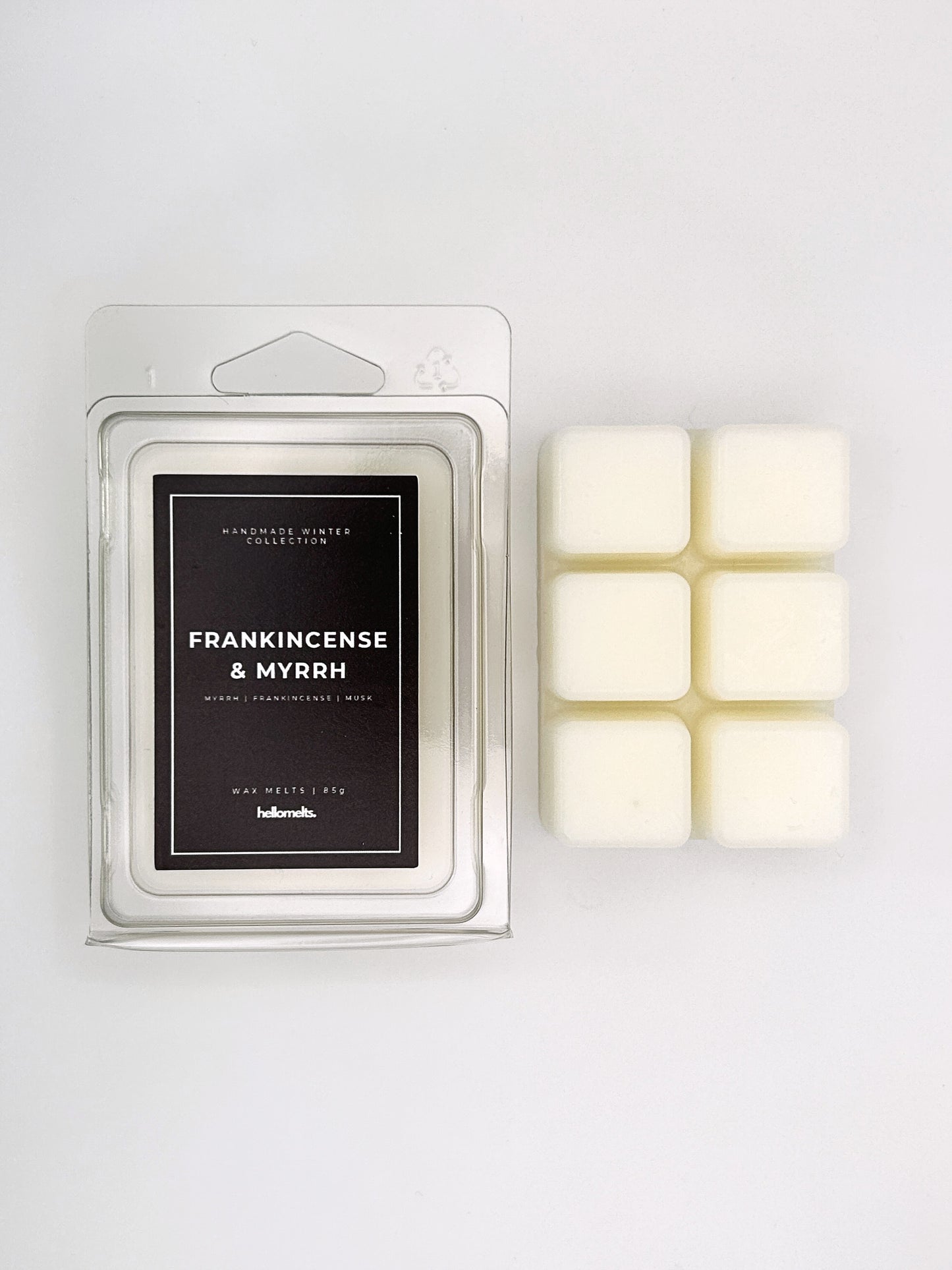 Frankincense & Myrrh 85g wax melt clamshell placed beside six wax cubes from the Hellomelts Winter Collection