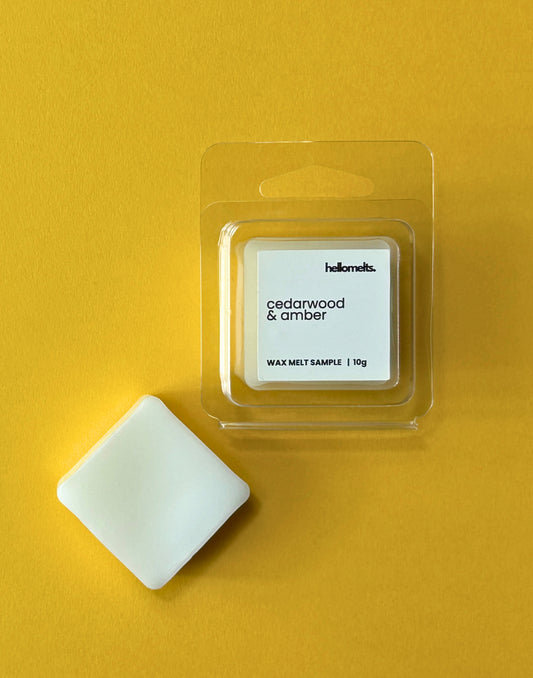 Hellomelts free wax melt sample in Cedarwood & Amber scent, 10g clamshell with one wax cube on a yellow background