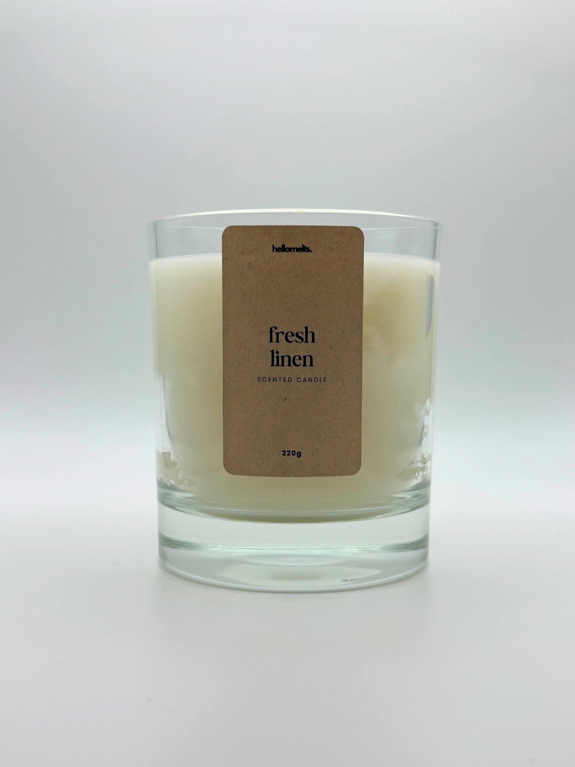 Front view of Fresh Linen scented candle by Hellomelts, featuring a clean white wax in a clear glass jar, part of the Spring Collection.