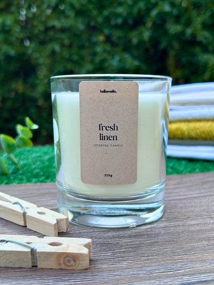 Fresh Linen scented candle by Hellomelts, shown in an outdoor spring setting with wooden pegs and soft natural textures, highlighting the clean, airy character of this Spring Collection fragrance
