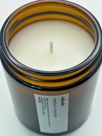 Close-up angled top-down view of Hazelnut & Chocolate autumn scented candle by Hellomelts, showcasing the smooth wax in an amber jar from the Autumn Collection