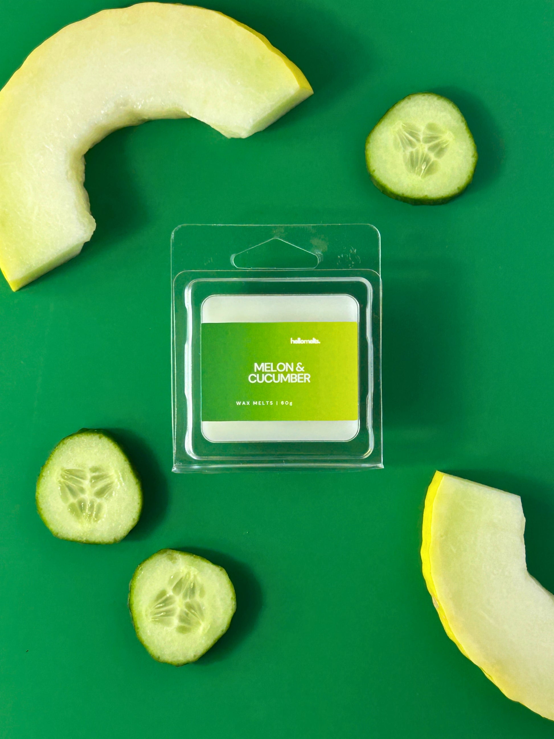 Melon & Cucumber wax melt bar by Hellomelts, photographed with cucumber slices and melon on a green backdrop, from the Summer Collection