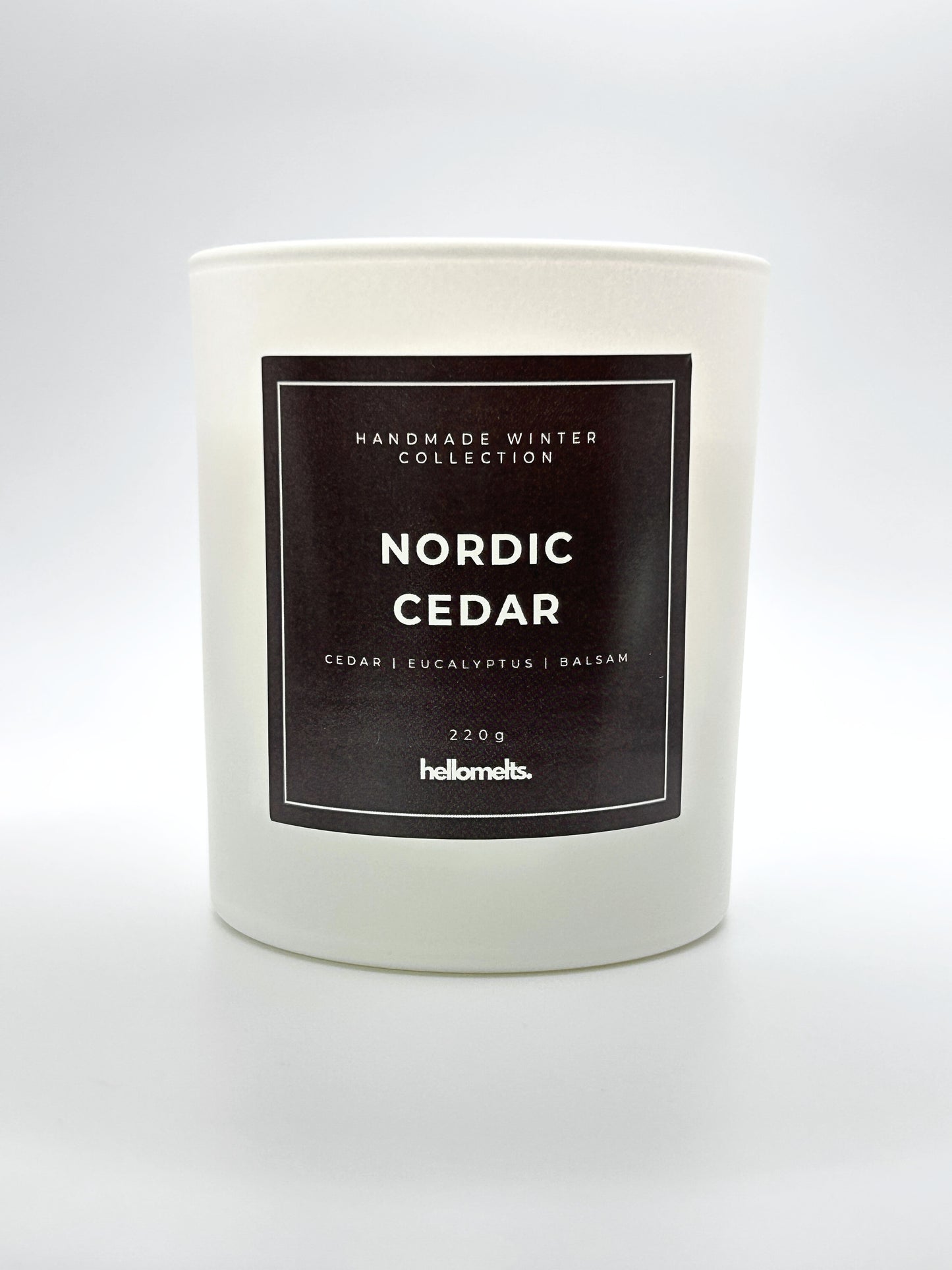 Nordic Cedar 220g candle front-facing studio shot without the lid, showing the clean white jar and label from the Hellomelts Winter Collection