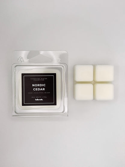 Nordic Cedar 60g wax melt clamshell placed beside four wax cubes from the Hellomelts Winter Collection