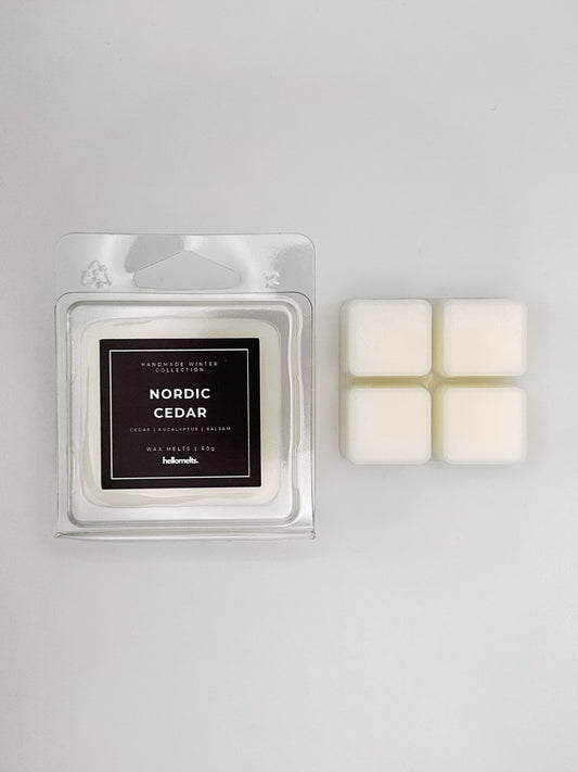Nordic Cedar 60g wax melt clamshell placed beside four wax cubes from the Hellomelts Winter Collection