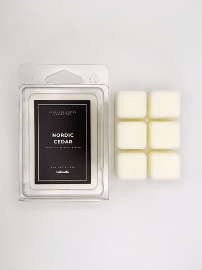 Nordic Cedar 85g wax melt clamshell placed beside six wax cubes from the Hellomelts Winter Collection