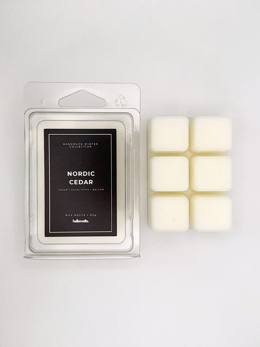 Nordic Cedar 85g wax melt clamshell placed beside six wax cubes from the Hellomelts Winter Collection