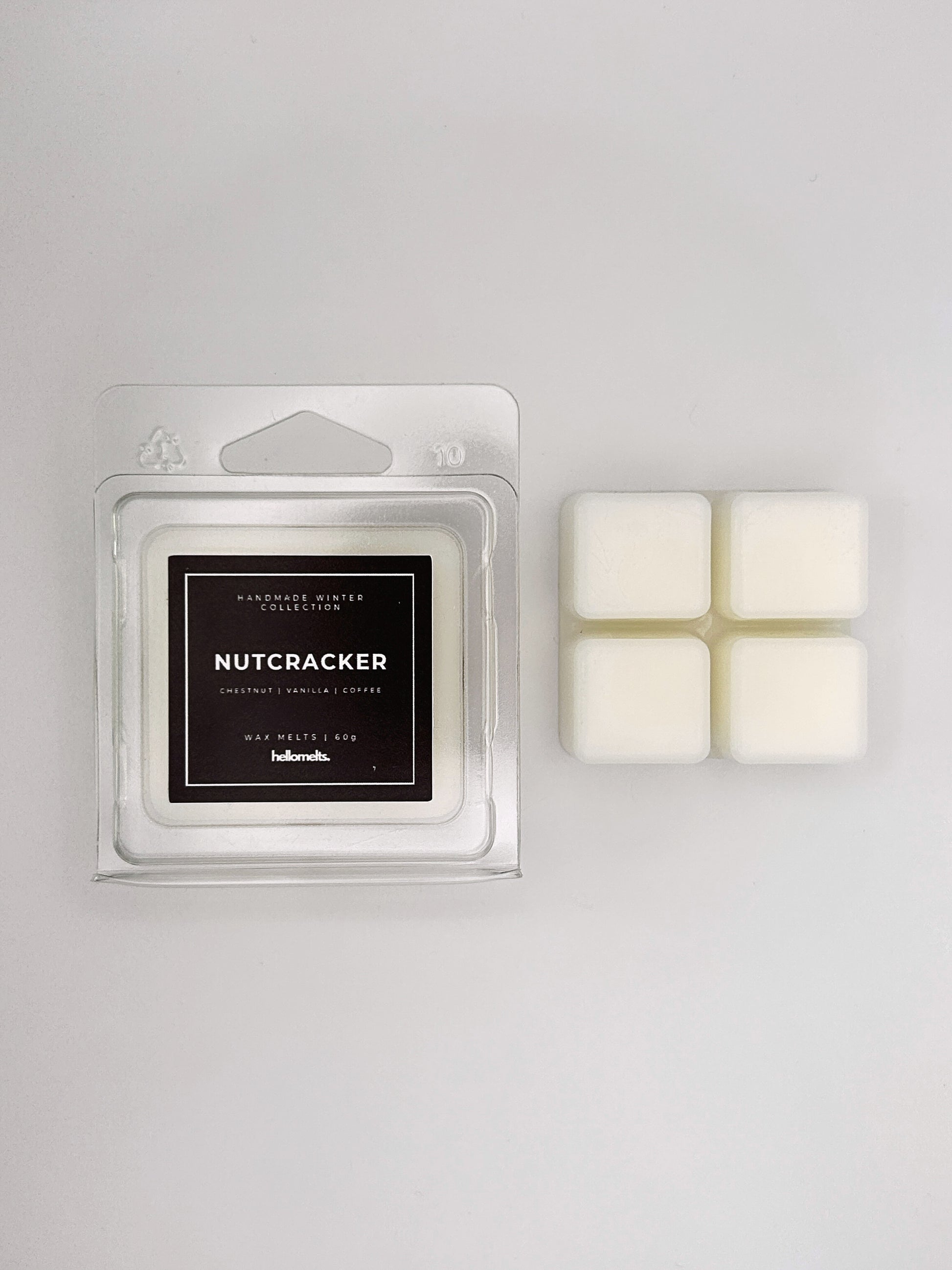 Nutcracker 60g wax melt clamshell placed beside four wax cubes from the Hellomelts Winter Collection