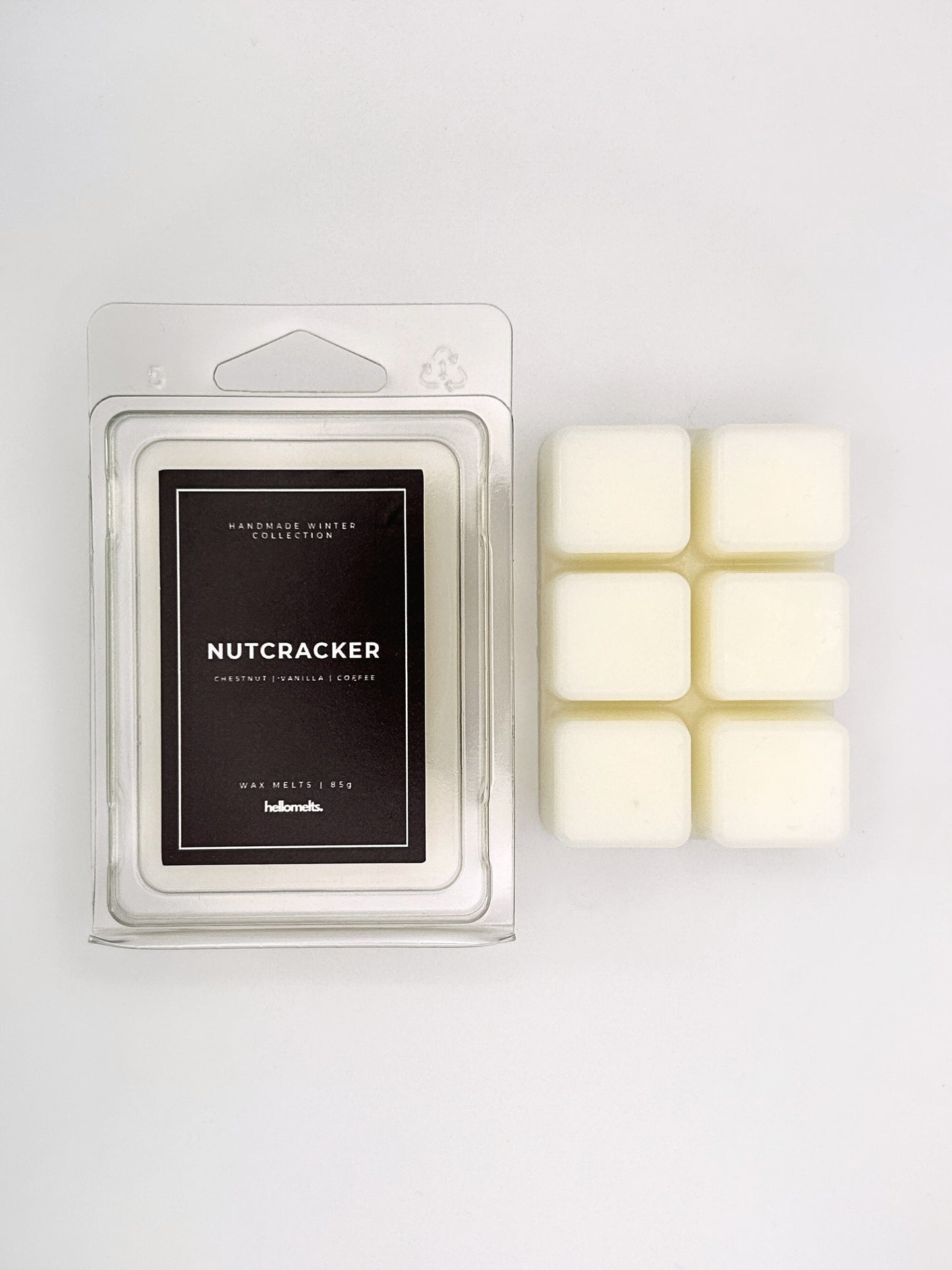 Nutcracker 85g wax melt clamshell placed beside six wax cubes from the Hellomelts Winter Collection