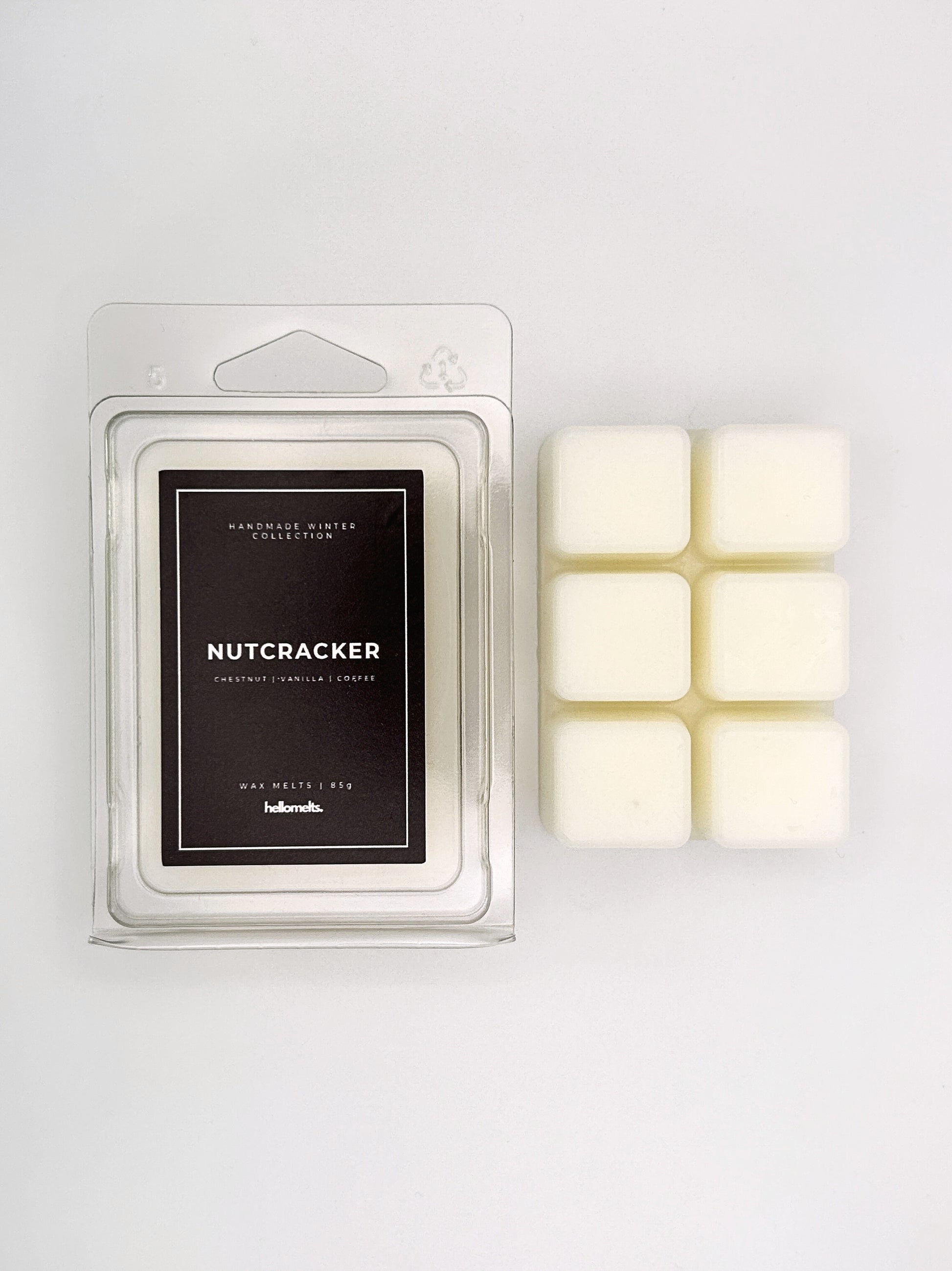 Nutcracker 85g wax melt clamshell placed beside six wax cubes from the Hellomelts Winter Collection