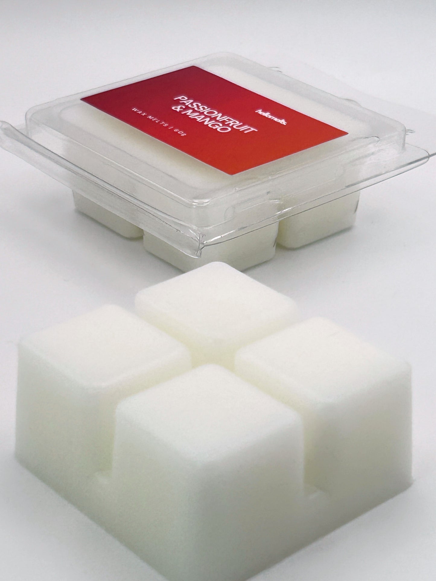 Angled shot of Passionfruit & Mango 60g wax melt bar in front of its packaging, part of the Summer Collection by Hellomelts