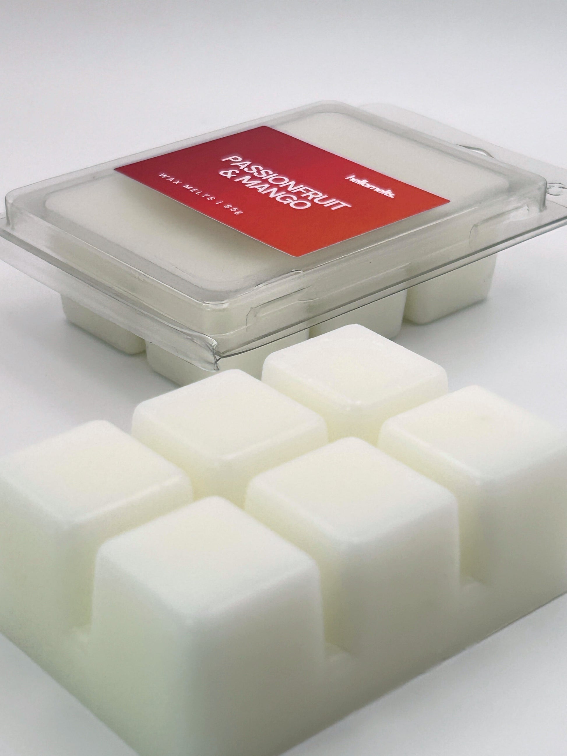 Angled shot of Passionfruit & Mango 85g wax melt bar in front of its packaging, part of the Summer Collection by Hellomelts