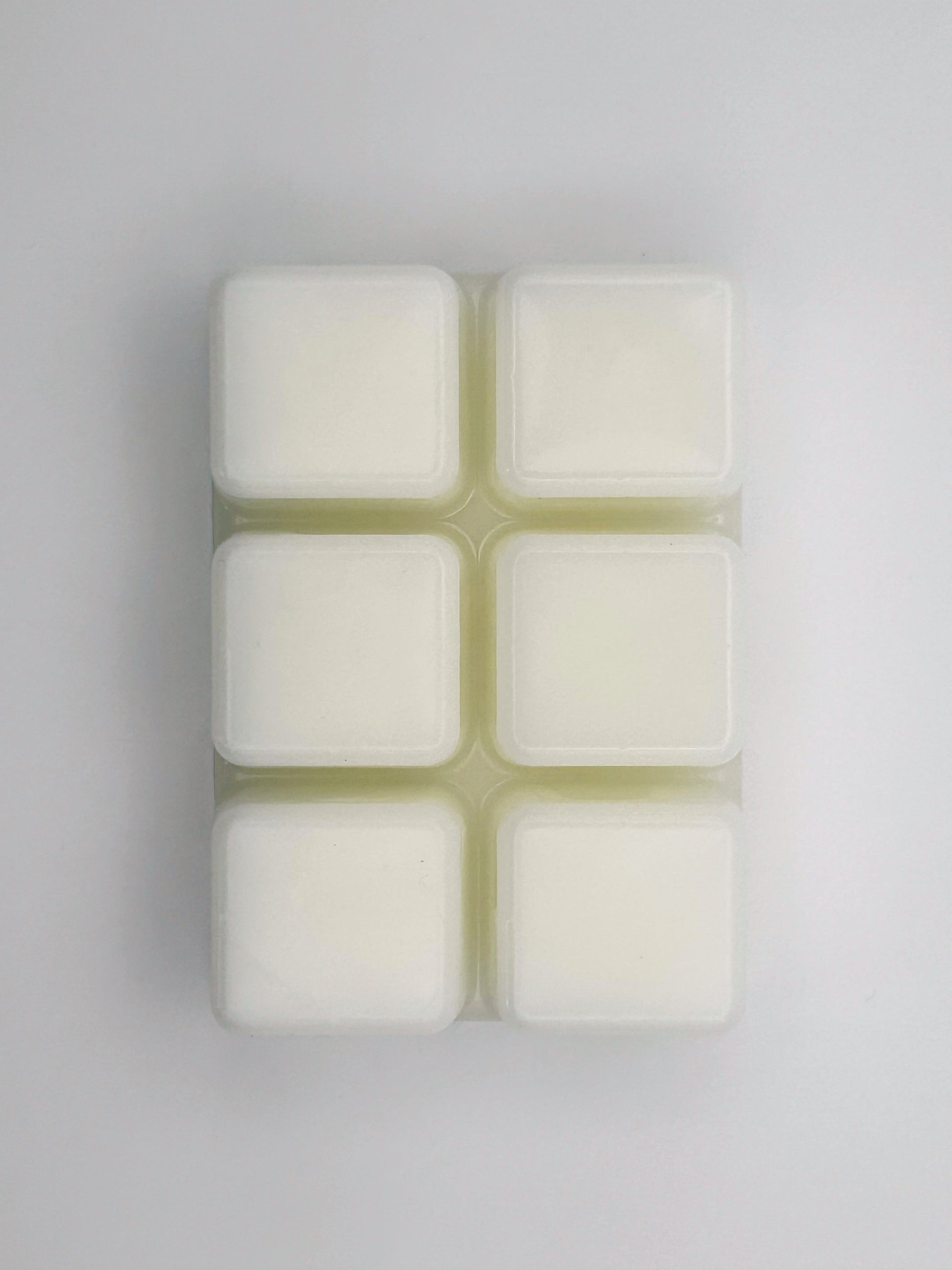 Flatlay of Passionfruit & Mango wax melt bar in 85g size, removed from packaging to show 6 cubed wax melt bar
