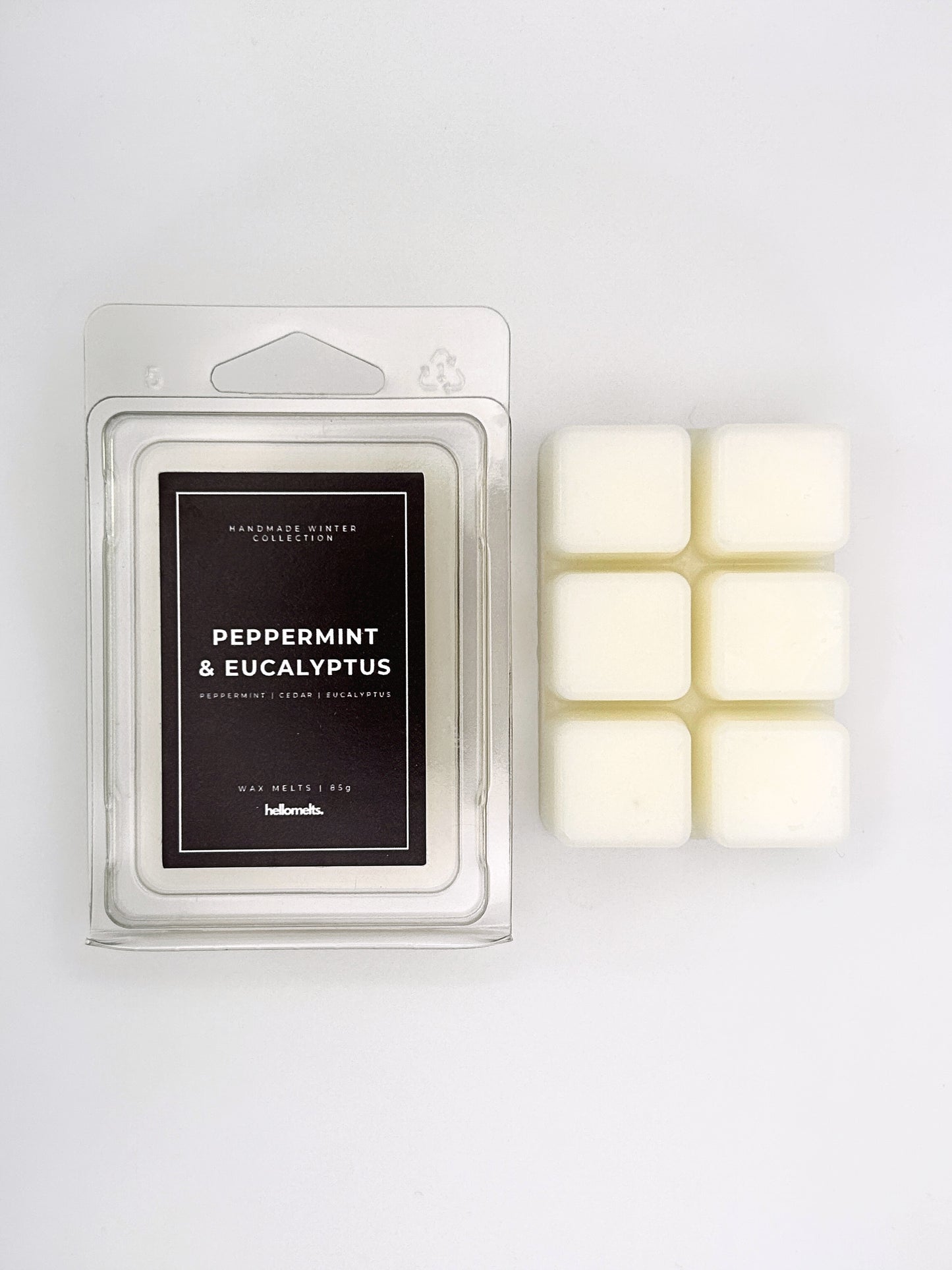 Peppermint & Eucalyptus 85g wax melt clamshell placed beside six wax cubes from the Hellomelts Winter Collection
