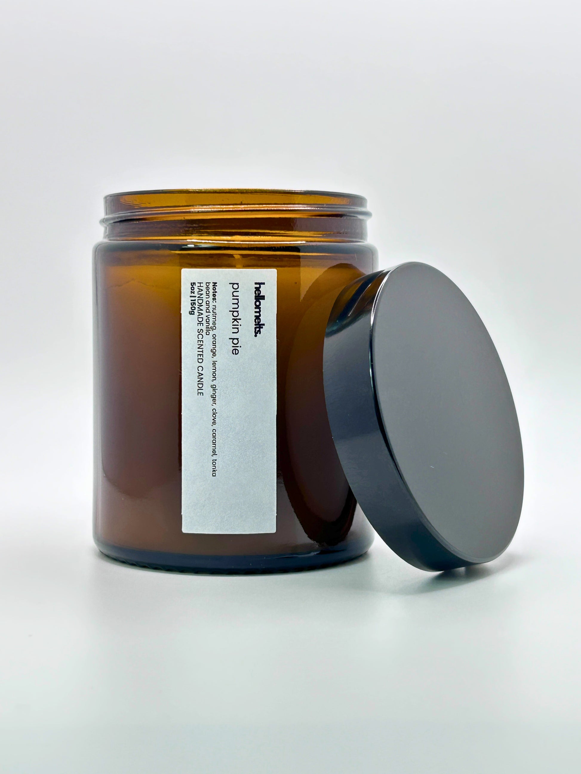 Front view of Pumpkin Pie autumn scented candle by Hellomelts with the lid placed beside it, part of the Autumn Collection